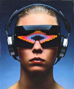 Head shot of a young woman wearing headphones, and large wrap-a-round glasses with colourful Atari VCS style graphics in the lenses. From one of Atari's 1976 Video Music magazine adverts.
